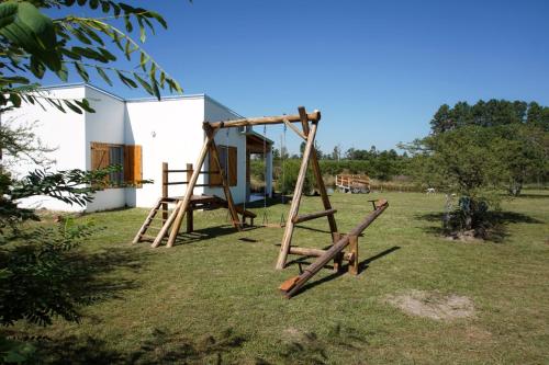 a swing set in a yard next to a house at "AGUAPÉ" Alojamiento rural con PILETA in Chajarí
