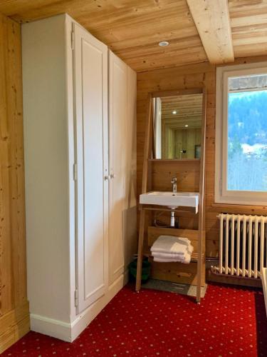 une salle de bain avec un lavabo et un miroir dans l'établissement Chalet familial et chaleureux, aux Contamines-Montjoie