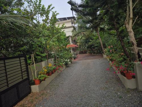 a walk way with plants and flowers in pots at Meadows Serene Retreat in Kannur