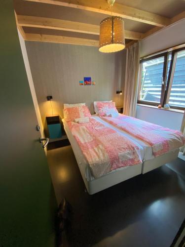 a small bedroom with a bed and a window at T kan Verkeren - Houseboat in Amsterdam