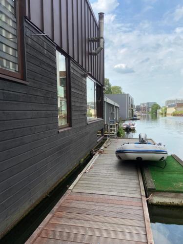 a boat sitting on a dock next to a building at T kan Verkeren - Houseboat in Amsterdam