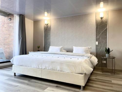 a bedroom with a large bed with white sheets at Apartamento 7, Parque de la 93 in Bogotá