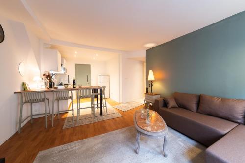 ein Wohnzimmer mit Sofa und Tisch in der Unterkunft Nid d'émeraude - Votre escale cosy à Haguenau in Haguenau