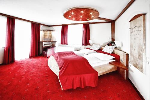 a bedroom with a large bed with a red carpet at Gasthof Gutmann in Eberstein