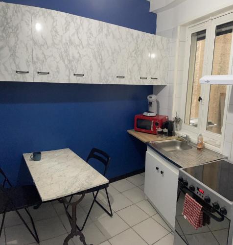 une petite cuisine avec une table et un évier dans l'établissement Le Bubble, à Épernay