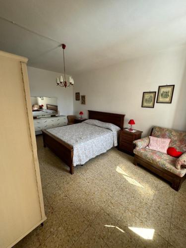 a bedroom with a bed and a couch at La casa in castello in Bolsena