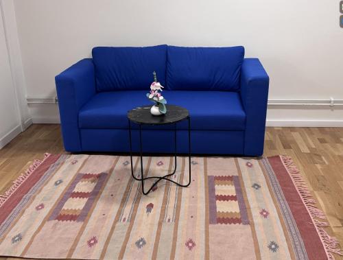 a blue couch in a living room with a table at Entire Apartment 50 sqm Modern & Free Parking in Umeå