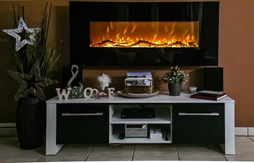 a white desk with a fireplace in the background at Ferienwohnung Blumäcker Oberbayern in Oberhausen