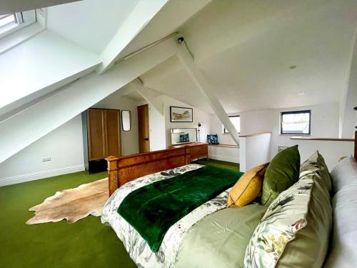 a bedroom with a large bed in a attic at Stunning fully refurbished house in New Quay