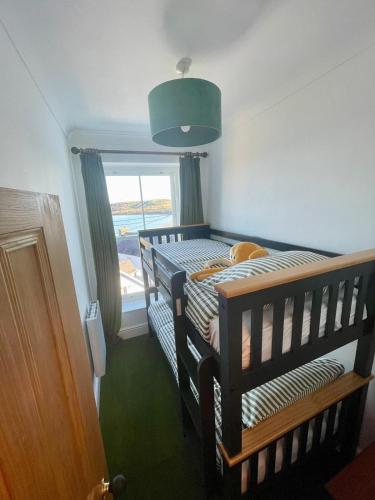 a bedroom with two bunk beds and a window at Stunning fully refurbished house in New Quay