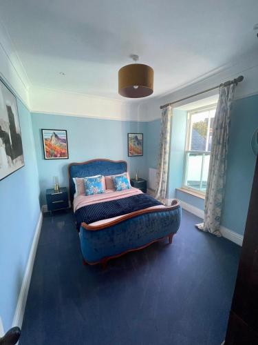 a bedroom with a bed and a large window at Stunning fully refurbished house in New Quay