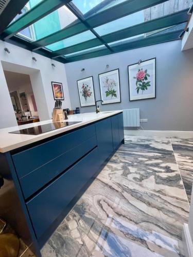a kitchen with blue cabinets and a marble floor at Stunning fully refurbished house in New Quay