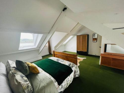 a attic room with a bed and a couch at Stunning fully refurbished house in New Quay