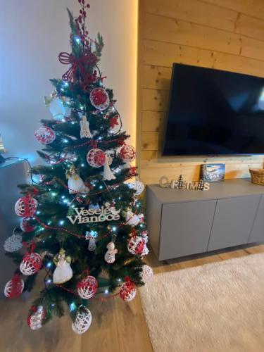 a christmas tree with ornaments on it in a living room at Chata Petra in Oravský Biely Potok