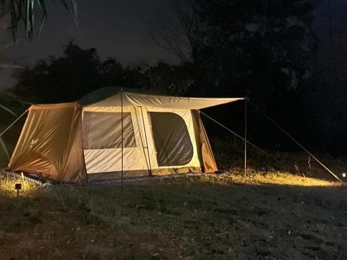 a tent is set up in a field at night at บ้านสวนคุณทอง in Wang Nam Khieo