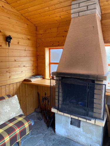 a room with a fireplace in a log cabin at Chata Petra in Oravský Biely Potok