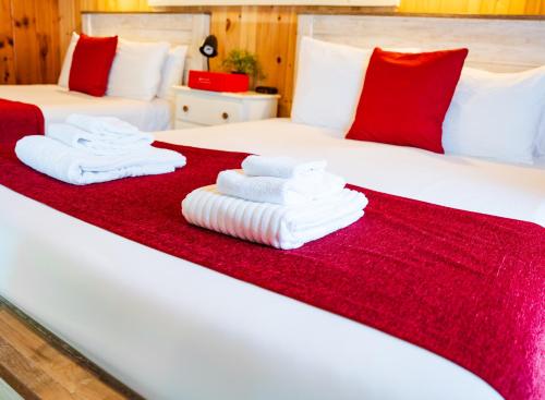 two beds with red and white towels on them at Cottage 4 - 1 Bed w/ Loft / 1 Bath & Courtyard in Wolfeboro