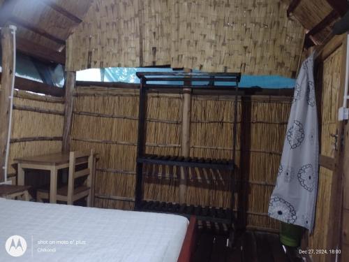 a room with a bed in a straw roofed room at Quest at Cape Maclear in Chembe