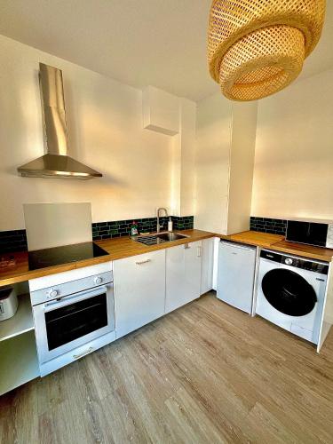 une cuisine avec des armoires blanches et un évier dans l'établissement Au bord du Périgord, à Sainte-Foy-la-Grande