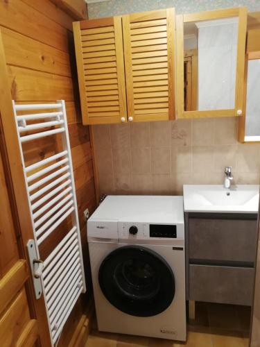 une petite cuisine avec une machine à laver et un évier dans l'établissement Chalet Paolina proche le Grand Bornand et la Clusaz, à Glières-Val-de-Borne