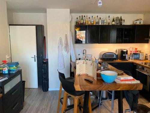 - une cuisine avec une table en bois et un comptoir dans l'établissement Super chambre avec salle de bain, Évry-Courcouronnes