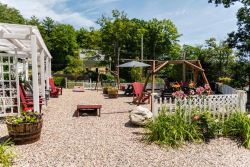 a garden with a white fence and a playground at Cottage 7 - Stand Alone 1 Bedroom / 1 Bath in Wolfeboro