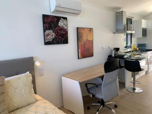 eine Küche mit einem Schreibtisch und Stühlen im Zimmer in der Unterkunft Ginjas Mountain Houses in São Vicente