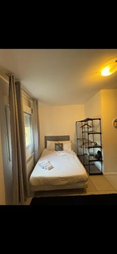 une chambre avec un lit et une étagère dans l'établissement Studio Cosy proche de Paris et Aéroport, à Vitry-sur-Seine
