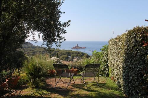 Deux chaises assises dans une cour avec l'océan en arrière-plan dans l'établissement Villa au Village de Cap Esterel, à Saint-Raphaël