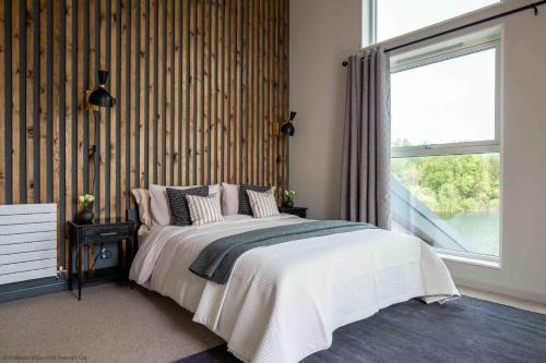 ein Schlafzimmer mit einem Bett und einem großen Fenster in der Unterkunft Maricor in South Cerney