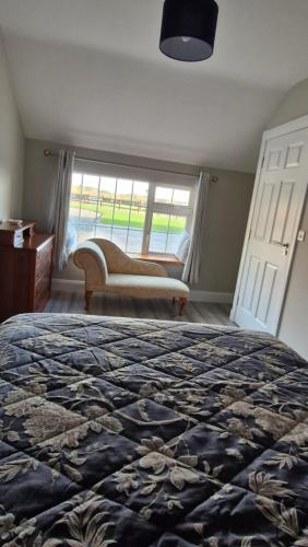 a bedroom with a bed and a window with a couch at Yellow Stone Farm Lodge in Clonbrown