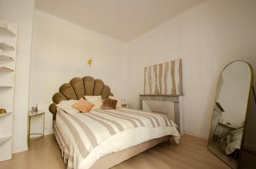 une chambre avec un grand lit et un miroir dans l'établissement Casamea - Apt Spacieux, Clim, Famille & Cabane, à Ajaccio