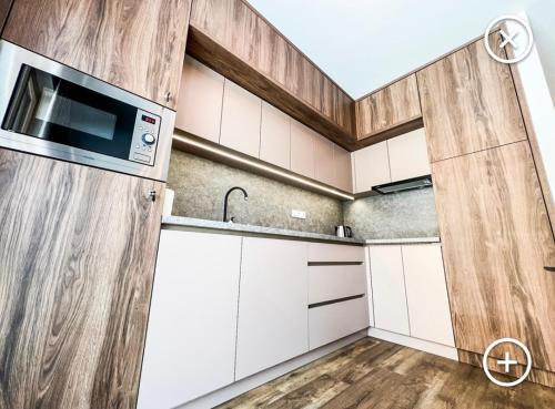a kitchen with white cabinets and a microwave at Apartmán Esprit Y31 in Dolný Kubín