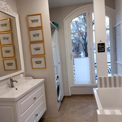 une salle de bain avec un lavabo et une machine à laver dans l'établissement Bel appartement Paris centre, à Paris