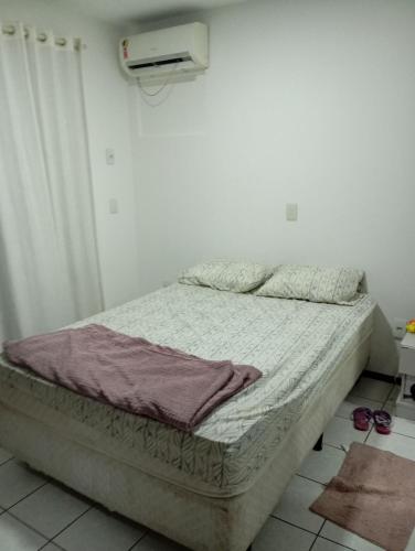 a bed in a white room with avertisementatronatronstrationstrationstration at Apartamento Itapema in Itapema