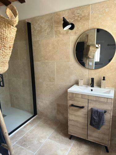 une salle de bain avec un lavabo et une douche avec un miroir dans l'établissement Le Mazet de Papi en Garrigue, à Saint-Gervasy