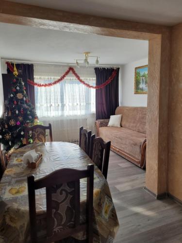 a living room with a christmas tree and a table at Mlynski in Mykulychyn