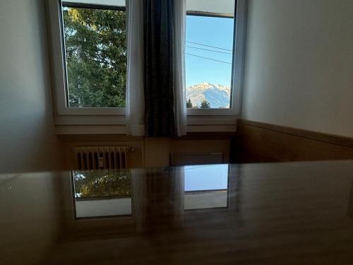 two windows in a room with a view of a mountain at La Tana del Gufetto in Marilleva
