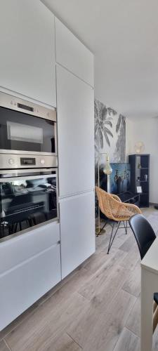 une cuisine avec des armoires blanches et un four dans l'établissement Maison Cosy Coco 1h Paris et 2h plages Normandie, à Broué