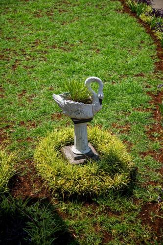 a statue of a bird bath in the grass at GARDEN HOLiDAY in Antsirabe