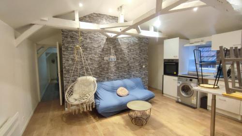 a living room with a blue couch and a swing at Centre Historique - Charmant T3 - 1h de l Océan in Orthez