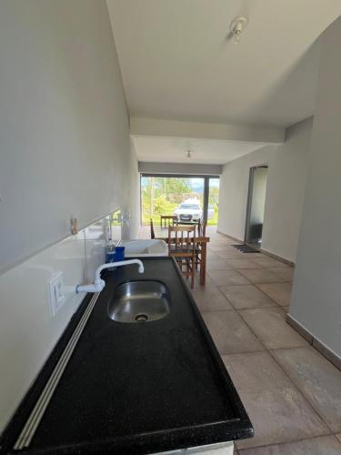 a kitchen with a sink and a table in a room at Casa de praia com suíte master in Arroio do Sal