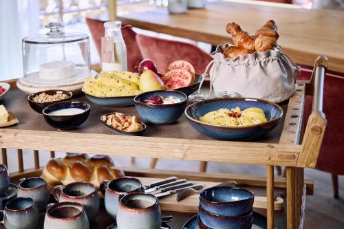 a table filled with different types of bread and pastries at BelArosa Chalet - the luxury hideaway in the Swiss Alps in Arosa