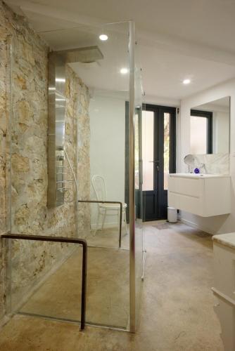 une salle de bain avec une douche en verre et un lavabo dans l'établissement JARDIN & VUE MER Maison des années 20 proche du centre historique, à Grasse