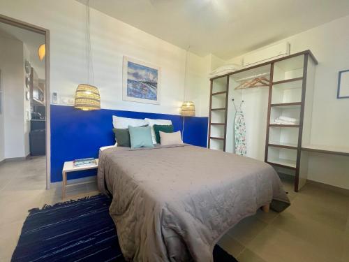 RémiréApt 1 chb belle déco résidence avec piscine的卧室里有一张大床和一面蓝色的墙