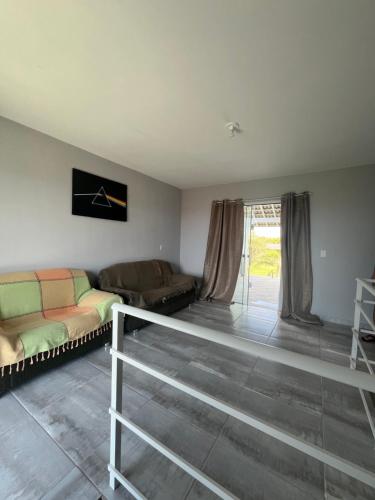 a living room with two couches and a couch at Casa de praia com suíte master in Arroio do Sal