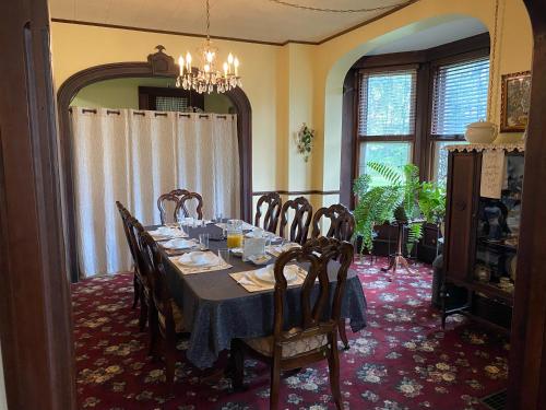 a dining room with a table and chairs and a chandelier at The Vine Bed & Breakfast, LLC in Dundee