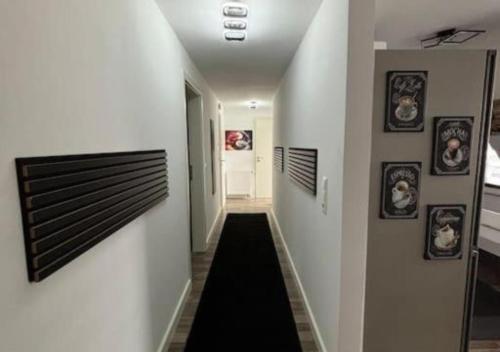 a hallway with white walls and a black rug at Moderne deluxe 3-Zi Eigentums- Maisonette-Wohnung IBM Bertrandt Mercedes in Ehningen