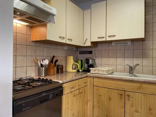 une cuisine avec des armoires en bois et un four à plaques de cuisson dans l'établissement Appartement 2 pièces BANYULS SUR MER BN000-004, à Banyuls-sur-Mer