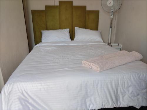 a large white bed with a towel on it at Willow's Guesthouse in Vereeniging